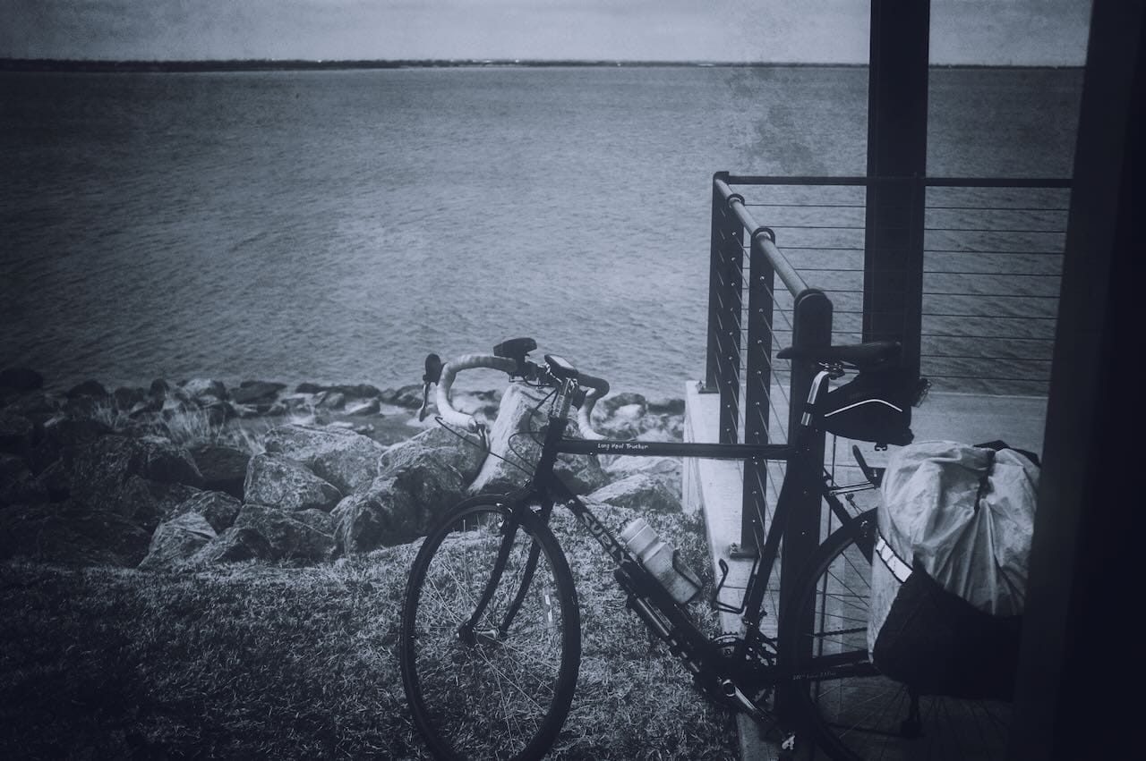 Color photo of bicycle leaning against a railing looking out over Lake Hefner.