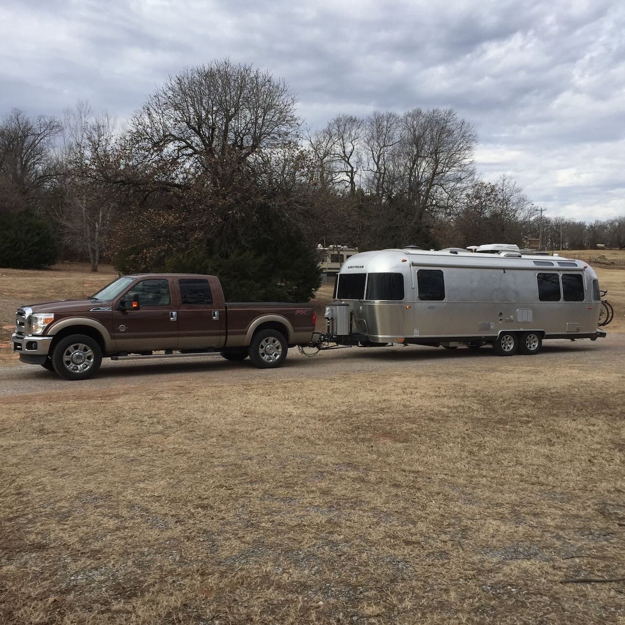 Color photo of an Airstream trailer hooked to a brown Ford pickup.