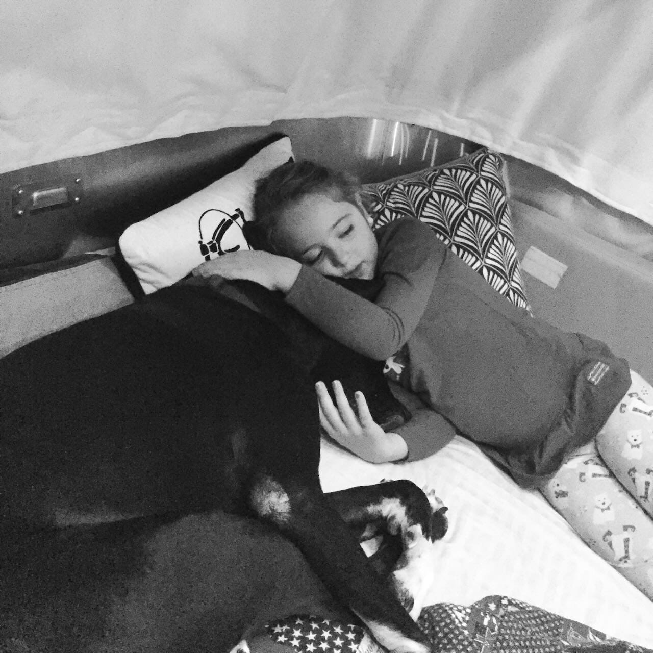 B&W photo of a young girld cuddling with a great dane.