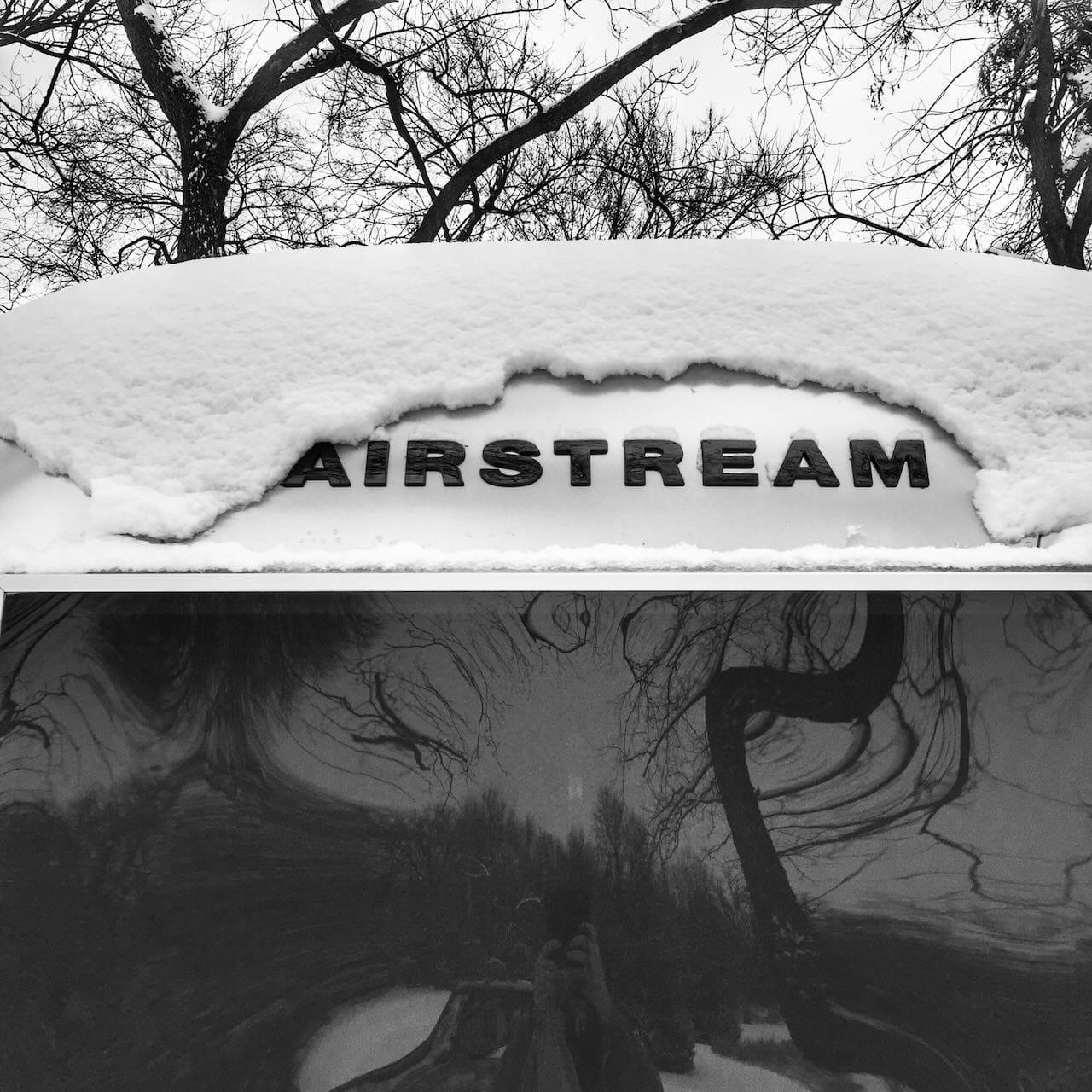 B&W photo of snow on an Airstream trailer.