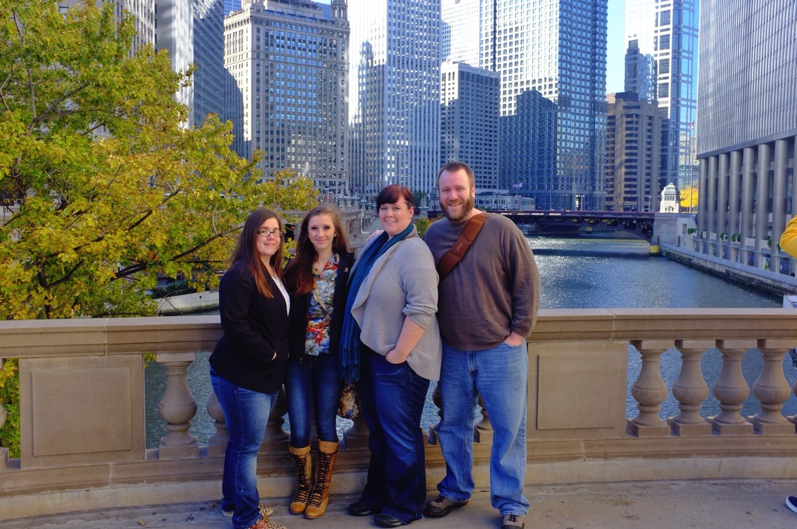 Color photo of the group standing on bridge over the Chicago River.